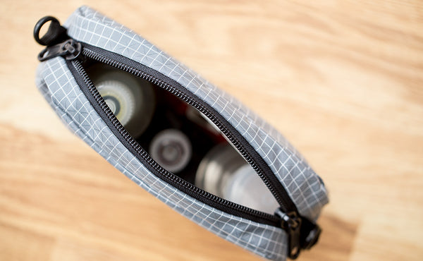 An assortment of items in a 3D Organizer Cube with the zipper open.